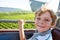 Smiling happy blond littlekid boy in cable funicular over vineyards in summer