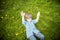 Smiling happy boy laying in grass outside picking flowers