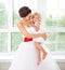 Smiling happy bride and a flower girl indoors