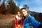 Smiling happy couple hikers with backpacks making selfie on the woods background while hiking in mountains in Western