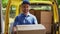 Smiling happy courier man in front of open van doors delivers package