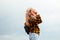 Smiling happy girl. Portrait preteen girl on the gray sky background. Girl 15 years old. Blonde long hair. Attractive