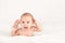 Smiling happy newborn infant baby tummy time on bed bright airy copy