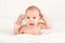 Smiling happy newborn infant baby tummy time on bed bright airy copy space childhood