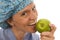 Smiling happy nurse doctor eating green apple