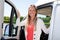 Smiling happy woman driving motor home rv camping van driver in driver seat in lifestyle vanlife