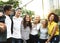 Smiling happy young adult friends arms around shoulder outdoors