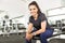 Smiling Healthy Female Sitting On Bench In Fitness Center