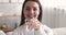 Smiling healthy woman holding glass of water looking at camera