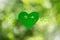 Smiling heart shaped green leaf with text think green on blurred bokeh background