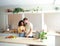 Smiling heterosexual diverse couple looking at mobile phone in apartment kitchen