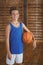 Smiling high school boy holding a basketball in the court