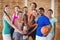 Smiling high school kids holding trophy in basketball court