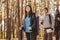 Smiling hikers looking at camera over pine forest background