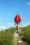 Smiling hiking young woman with backpack and trekking poles