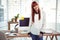 Smiling hipster businesswoman front of her desk