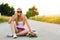 Smiling hipster teenage girl with skateboard, image with sunflare