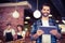 Smiling hipster using tablet in front of working barista