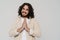 Smiling hispanic man doing pray gesture with folded hands while standing isolated