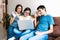 Smiling hispanic teen female with down syndrome and her family using laptop at home, in disability concept in Latin America