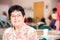 Smiling Hispanic Woman in a Busy Senior Center