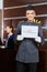 Smiling hotel concierge holding sign