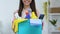 Smiling housewife with basket of detergents looking at camera, cleaning service