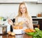 Smiling housewife cooking potatoes with electric steamer