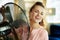 Smiling housewife enjoying breeze air in front of working fan