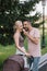 smiling husband feeding wife with ice cream near baby carriage