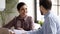 Smiling Indian businesswoman intern listening to mentor at meeting