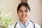 Smiling indian female doctor wear white coat look at camera, headshot portrait.