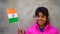 Smiling Indian teen showing the Indian flag and indicating the victory on Covid 19 pandemic. 72 th Victory Day of India concept