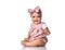 Smiling Infant baby toddler in polka dot dress and headband with bow sits on the floor holding hand up