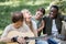 Smiling interracial teenagers with acoustic guitar