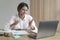 Smiling Italian young businesswoman in headset talking with colleagues during online meeting