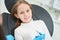 Smiling joyful little patient in dentist office