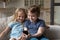 Smiling joyful small kids sibling using smartphone apps.