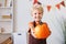 Smiling kid boy laughs and holding pumpkin with during Halloween celebration