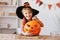 Smiling kid boy laughs and holding pumpkin Jack-o-lantern with during Halloween celebration