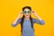 Smiling kid girl with stylish braided hair in party glasses on yellow background, fun