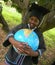 Smiling kid in graduation dressing holding world globe map