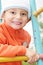 Smiling kid in orange on climbing staircase