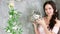 Smiling lady posing for camera holding cute white rabbit in wicker grey basket, spring photo session