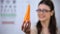Smiling lady in spectacles proposing fresh carrot, organic nutrition for vision