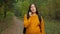 Smiling lady traveler talks on smartphone in autumn forest