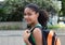 Smiling latin female student with bag in the city