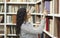 Smiling latina woman taking book at library