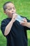 Smiling latino boy drinking water