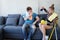 Smiling and lazy Young Caucasian couple love husband and wife funny and relaxing with Spray together on sofa for housework in